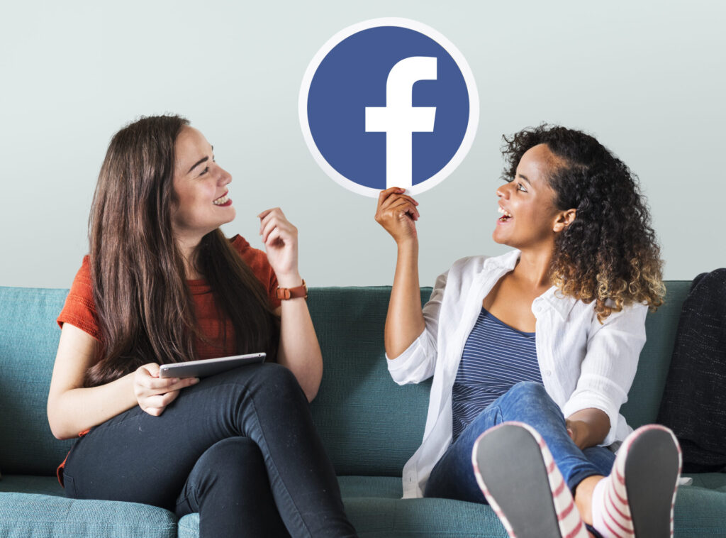 young women showing facebook icon